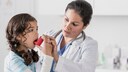 richtig inhalieren: Ärztin zeigt Mädchen den Umgang mit einem Inhalator