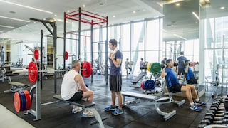 Menschen im Fitnessstudio beim Trainieren und Sprechen.