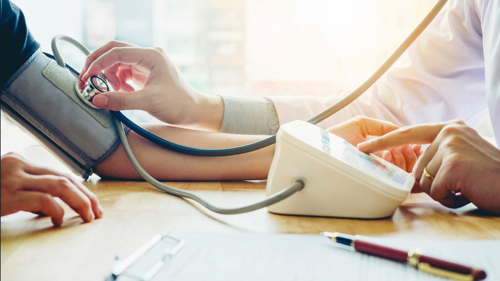 Blutdruck senken: Therapie bei Hypertonie. Arzt misst den Blutdruckwert