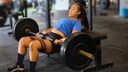 hip thrust: Frau trainiert mit Langhantel