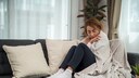 Immunschwäche nach Covid-19: Kränkelnde Frau auf der Couch
