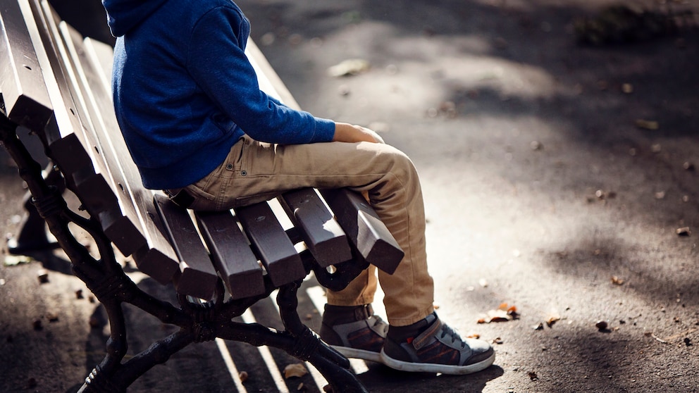 Autismus: Junge sitzt alleine auf einer Bank