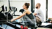 Schlaf Training: Frau und Mann im Gym an Rudergeräten