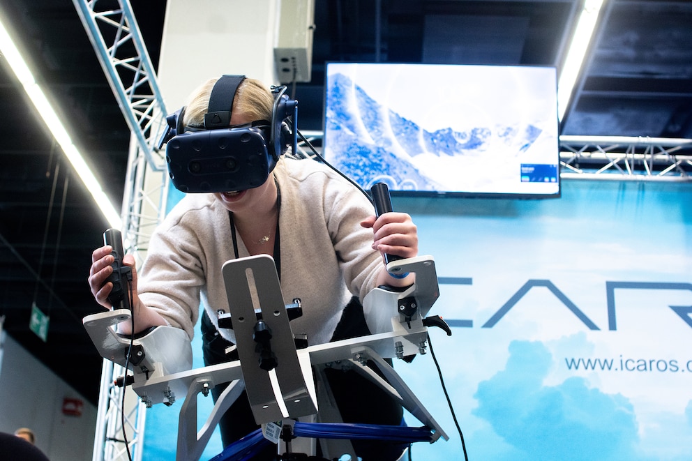 Eine Besucherin probiert ein Training mit Virtual-Reality-Brille auf der FIBO 2023 aus