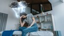 Frau mit Kopfschmerzen auf einem Bett