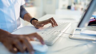 Stress PC: Person arbeitet mit Tastatur und Maus an einem Rechner