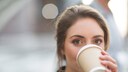 Junge Frau trinkt Kaffee aus To-Go-Becher