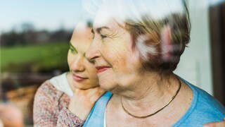 Alzheimer-Medikament Donanemab macht Hoffnung: Seniorin schaut aus dem Fenster, umarmt von jüngerer Frau