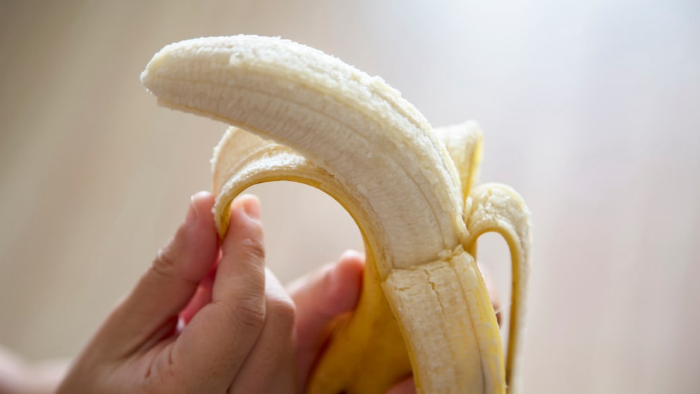 bananen frühstück: Person schält eine Banane
