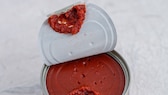 Opened pull open top tomato paste can on decorative surface. High point of view. Selective focus.