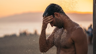 Körper runterkühlen: Ein Mann duscht am Strand