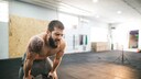 Muskulöser Sportler stützt sich erschöpft ab