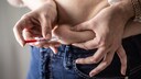 ozempic nebenwirkungen: Eine Frau setzt sich eine Spritze am Bauch