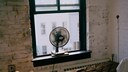 Mann liegt im Bett bei ge&ouml;ffnetem Fenster, Ventilator