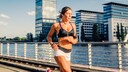 Frau läuft in der Sonne nur mit Sport-BH und Shorts