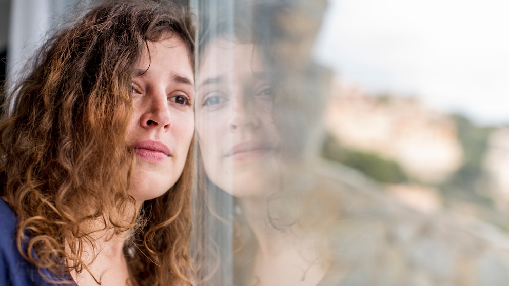 Bipolare Störung Symptome: Frau am Fenster