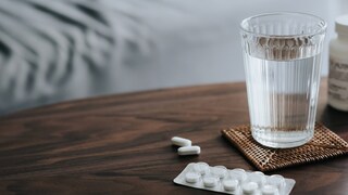 medikamente dehydrierung: Tabletten neben einem Glas mit Wasser