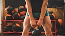Frau mit muskulösen Beinen und Kettlebell
