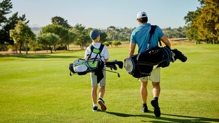 Die besten Golfschläger-Sets: Vater geht mit Sohn über Golfplatz