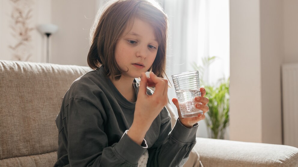 Mädchen nimmt ein Nahrungsergänzungsmittel für Kinder