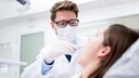 Zahnarztkosten: Zahnarzt schaut Patientin in den Mund