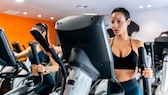 fettverbrennungszone abnehmen: Zwei Frauen im Gym auf einem Crosstrainer