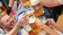 Wiesn-Besuch abtrainieren: Menschen sto&szlig;en mit Bierkr&uuml;gen an