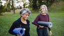 Körpergewicht Lebenserwartung: Zwei Frauen mit Yoga-Matten