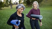 Körpergewicht Lebenserwartung: Zwei Frauen mit Yoga-Matten