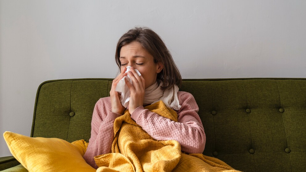 Long Cold oder chronische Erkältung? Frau putzt sich die Nase