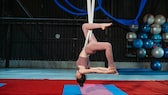 Beim Aerial-Yoga werden die Übungen hängend in einem Tuch durchgeführt