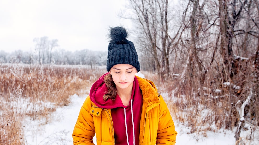 Junge Frau geht im Winter spazieren