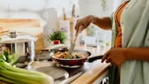 Frau kocht eine proteinreiche Mahlzeit