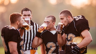 American Footballspieler trinken Bier.