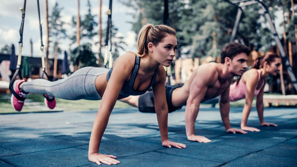 Mehrere Personen machen TRX-Training.