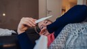 Frau schaut auf ein Fieberthermometer