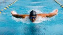 Mann mit Badekappe schwimmt