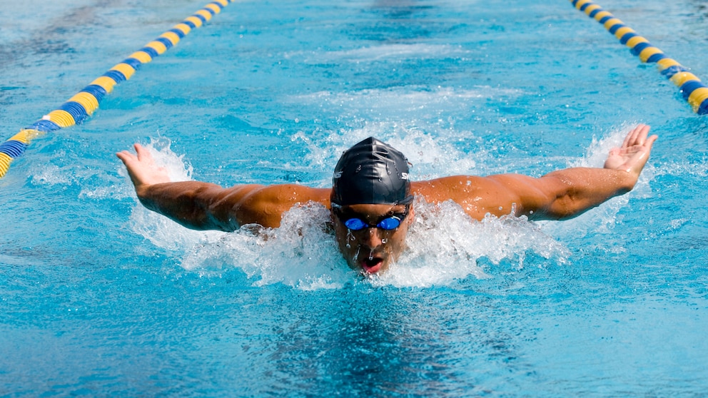 Mann mit Badekappe schwimmt