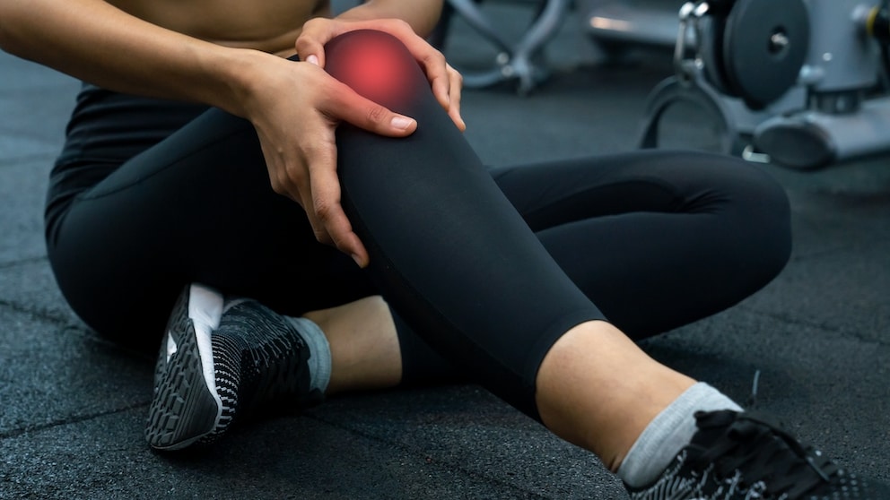 Frau fasst sich ans Knie