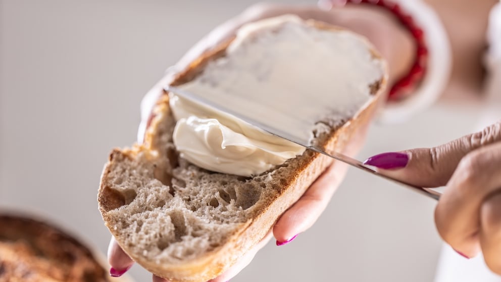 Butter wird aufs Brot gestrichen