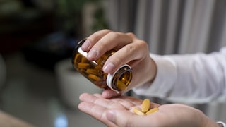 Tabletten aus der Flasche in die Hand