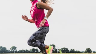Frau mit Laufuhr joggt im Freien