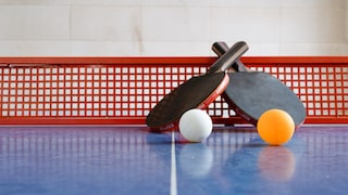 Tischtennisschläger und Bälle auf einer Platte