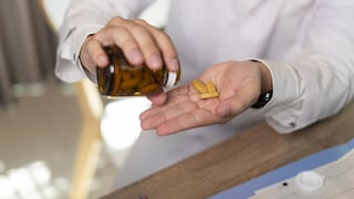 Mann nimmt Supplements beziehungsweise Nahrungsergänzungsmittel aus Flasche
