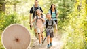 Familien beim Outdoor-Sport sollten sich vor Zeckenbissen schützen.
