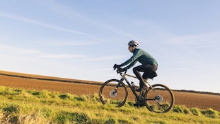Jemand fährt Gravel Bike auf dem Feld