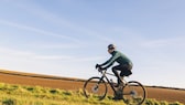 Jemand fährt Gravel Bike auf dem Feld