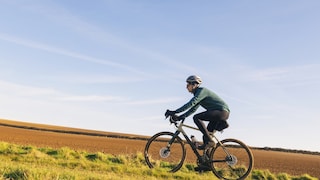 Jemand fährt Gravel Bike auf dem Feld