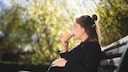 Eine schwangere Frau trinkt Kaffee.