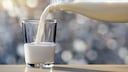 Milch aus einer Flasche in ein Glas